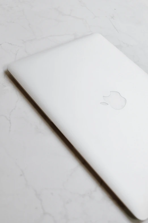 an apple laptop sitting on top of a white table