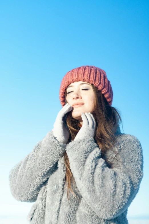 a beautiful young woman standing with her eyes closed