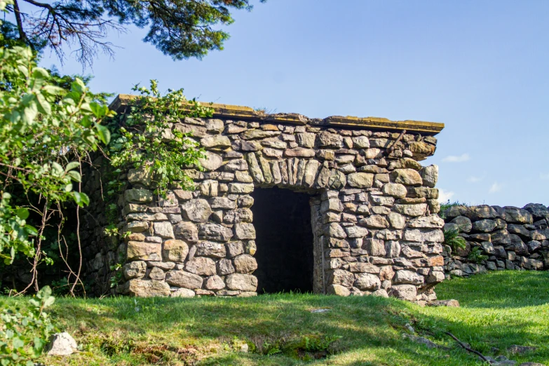 this is a rock building in the middle of some grass