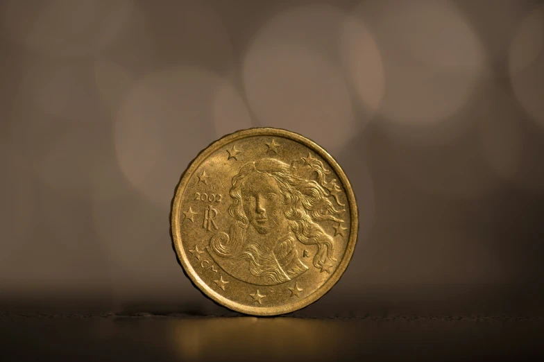 a gold coin sits on a brown background