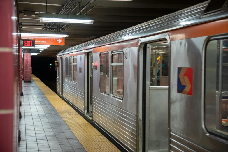 subway train approaching the platform with doors opened at night