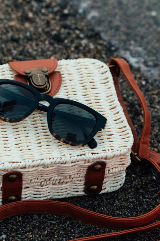 a wicker case with some sunglasses sitting on it
