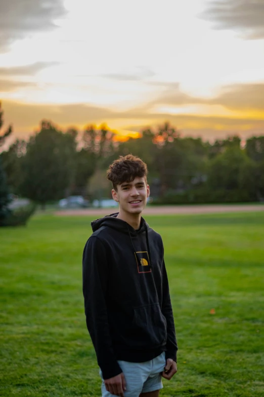 a boy in shorts is standing in the grass