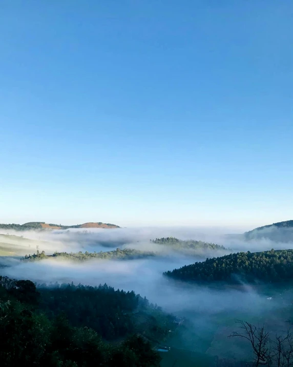 a few hills that are covered in low lying clouds