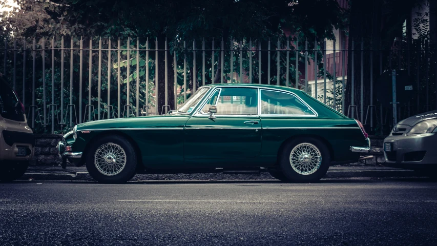 an old green car in a parking lot