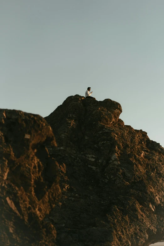 a couple of people sitting on top of a rocky cliff