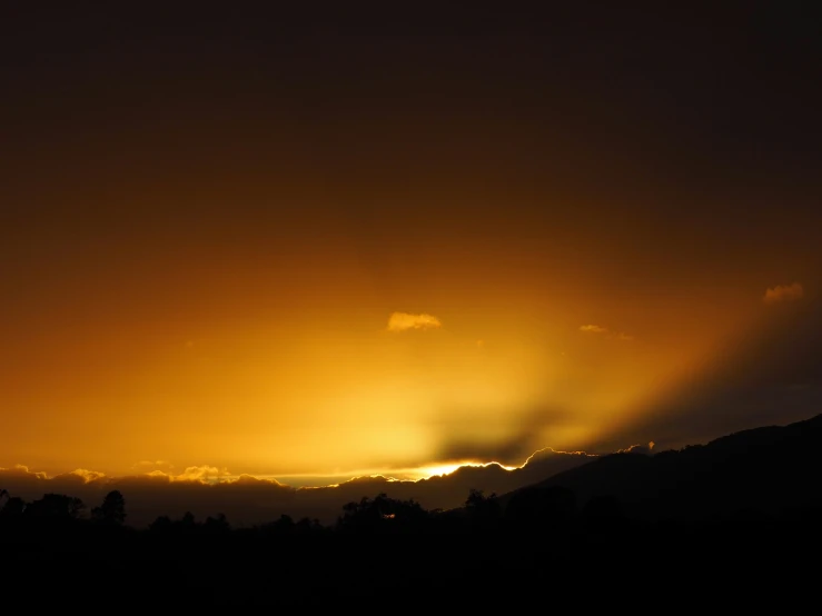 the sun shining down in the clouds over trees