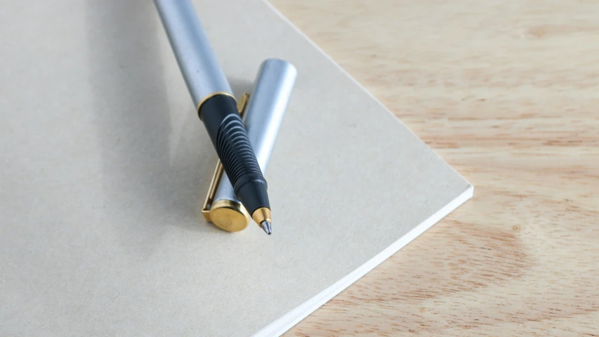 a fountain pen resting on top of an unplugged notebook