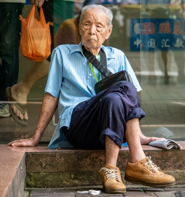 an elderly man in front of a window with his shoes