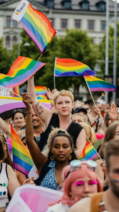 a large crowd of people gathered in a city with pride flags