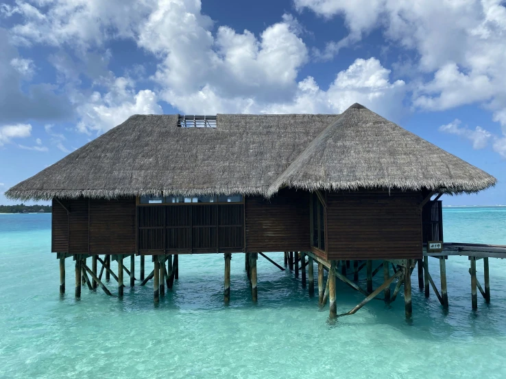 an overwater area with water and a house that has grass on top