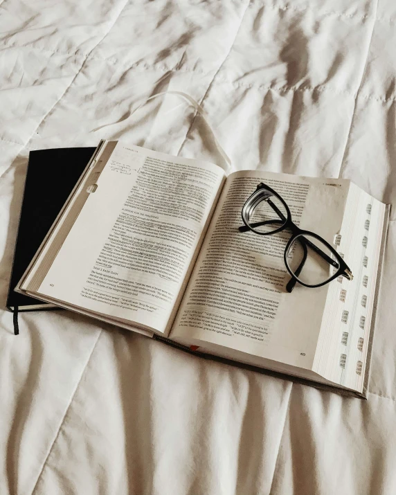 an open book on top of an unmade bed