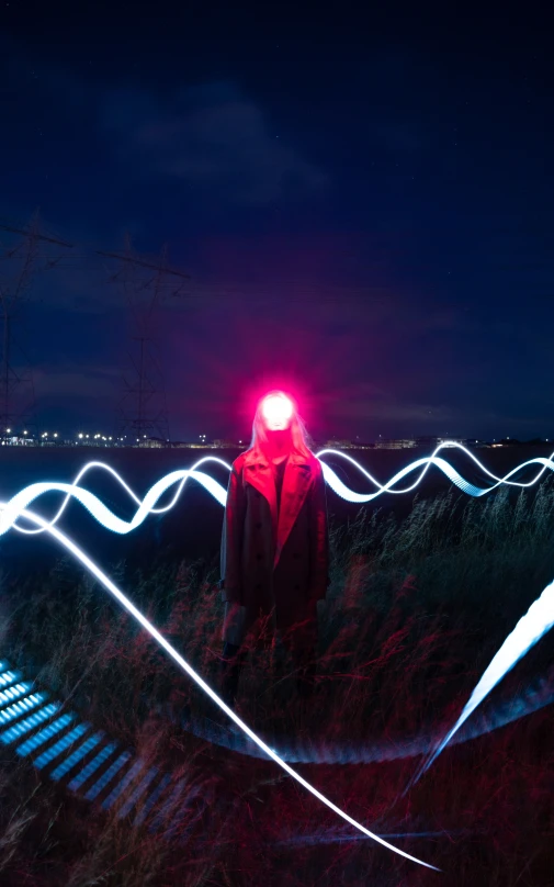 someone standing next to some wires with a red light on them