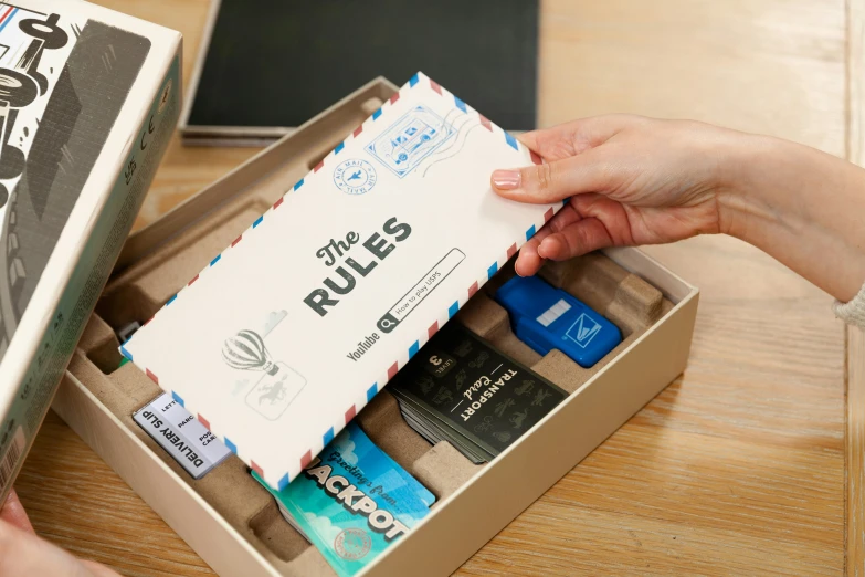 person opening open box of small rolls on table