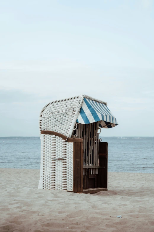 a wooden shack next to the ocean on a beach