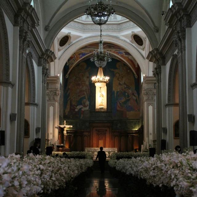 a large church with a chandelier and flower arrangement