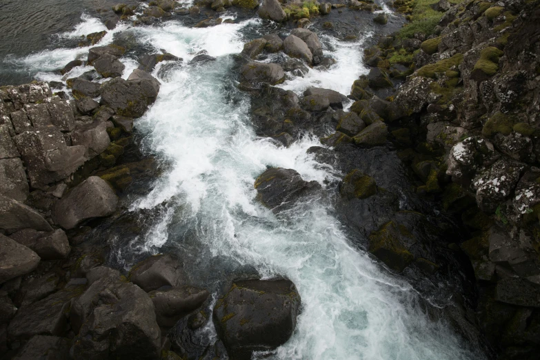 a stream of water flowing between some rocks