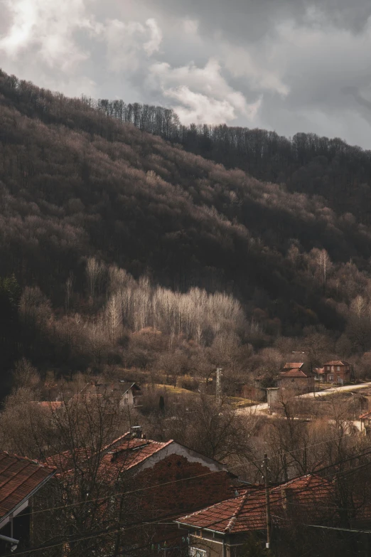 a house sitting in the distance with a forest below