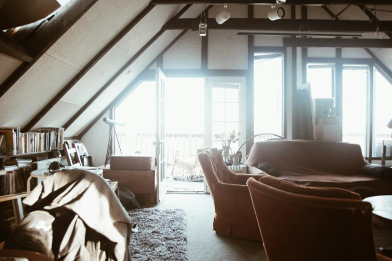 a loft with lots of tall windows and wooden floors