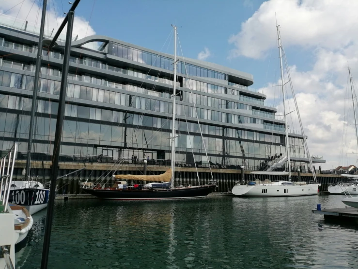 sailboats and yachts docked in front of a large building