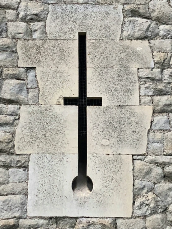 a stone cross on a stone wall