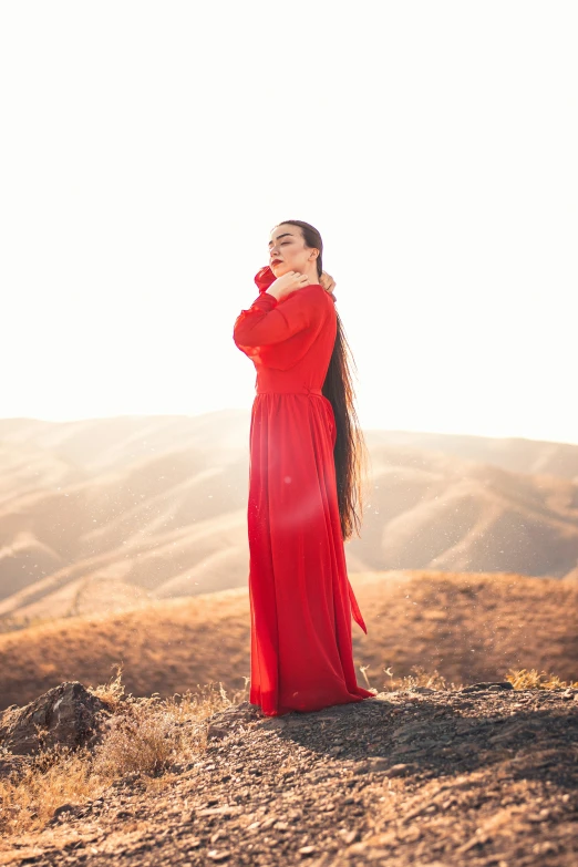 a woman standing on top of a lush green hillside