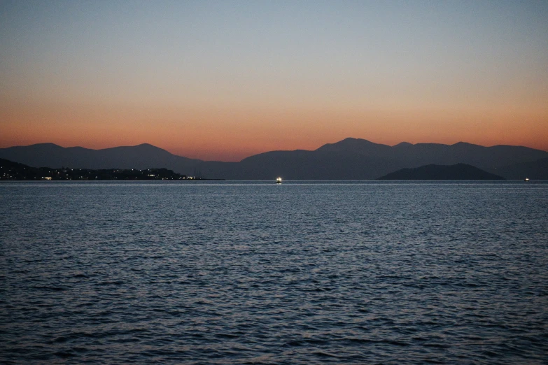 view of mountains from the ocean at dusk