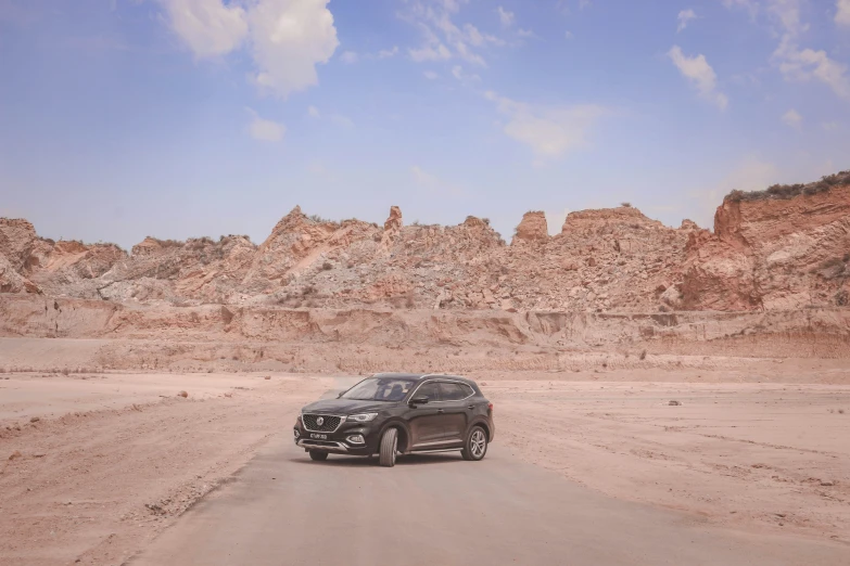 a black suv in the middle of a barren plain