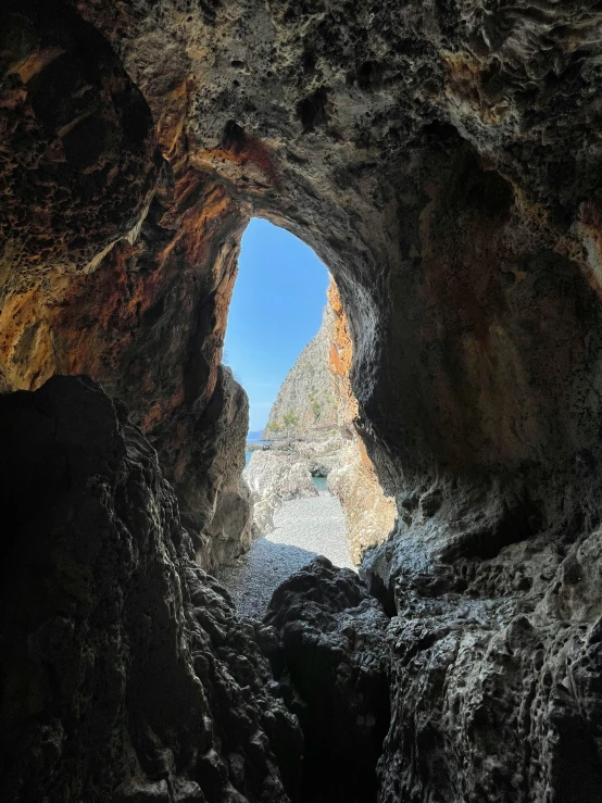 the entrance to a cave that is surrounded by rocks