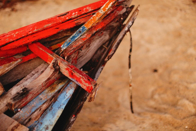 red strips of wood are lying on the sand