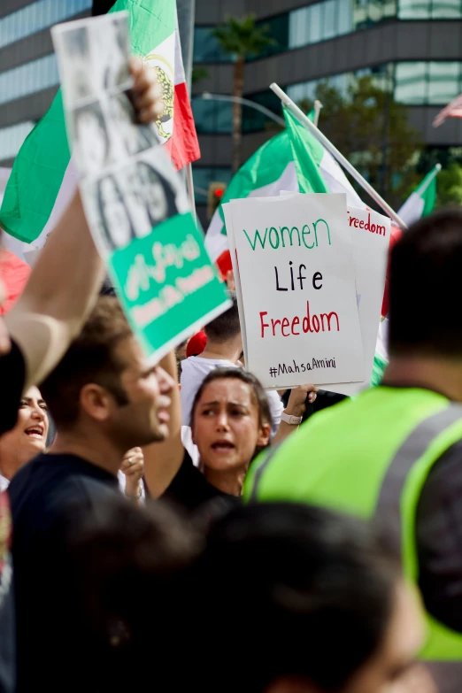 a crowd of people standing next to each other with signs