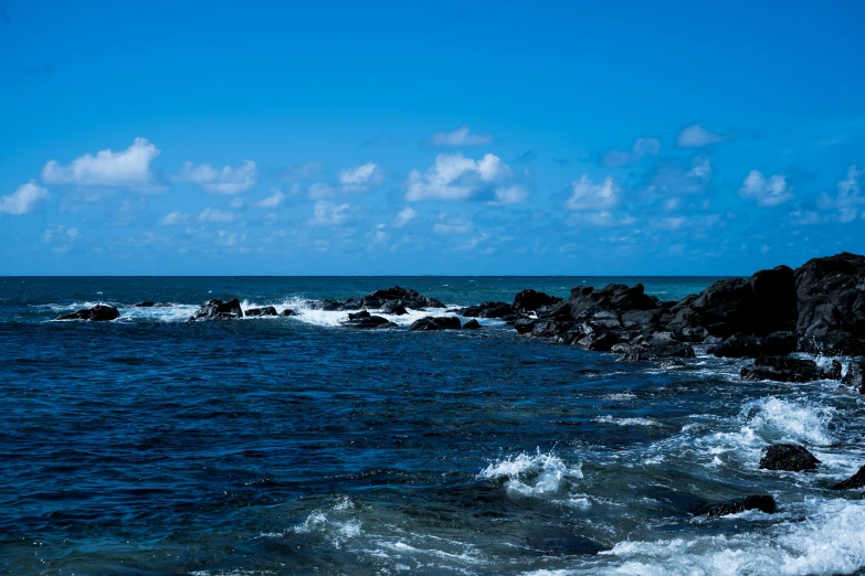 the ocean has many large rocks and small waves