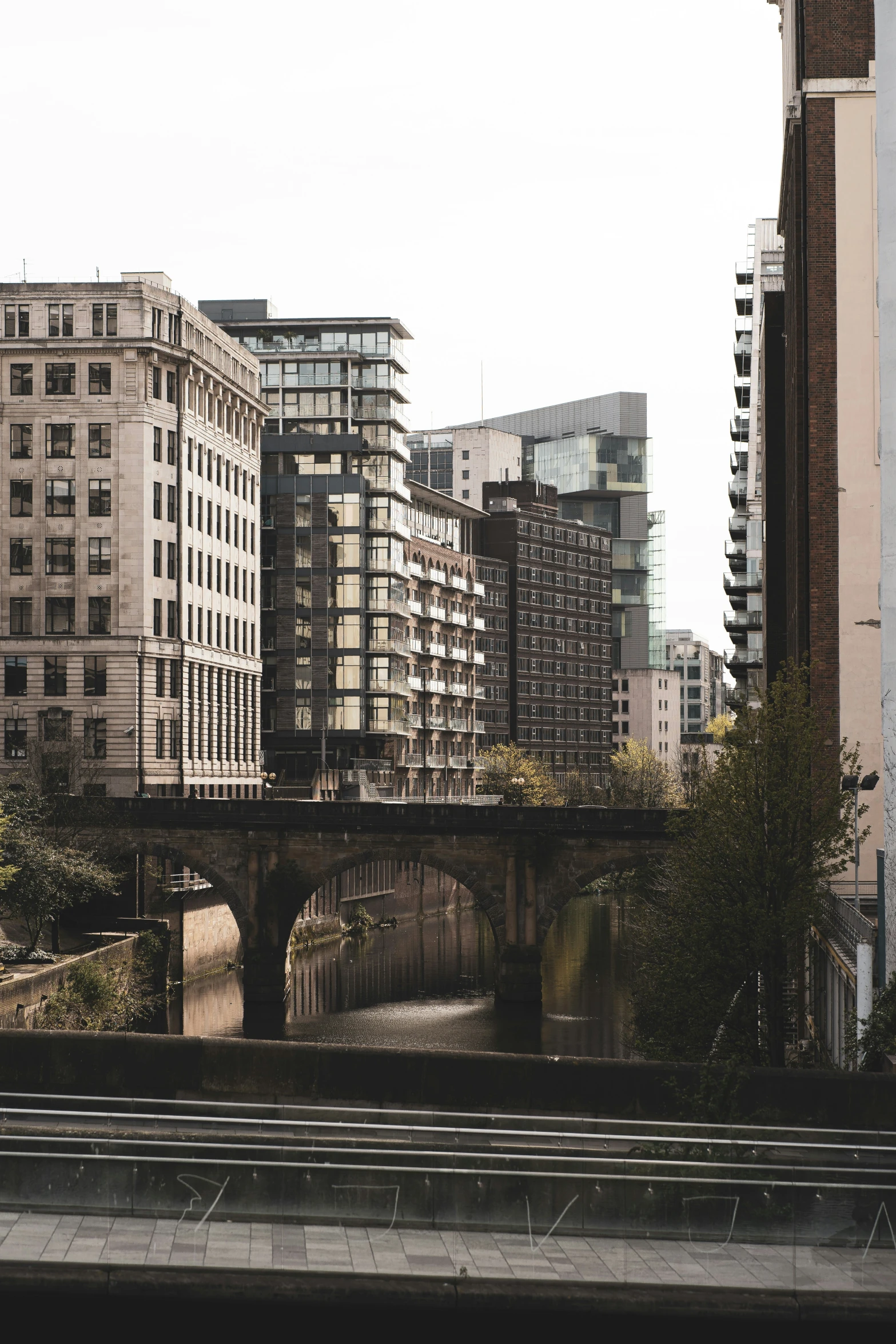 a bridge crosses over a river through some tall buildings