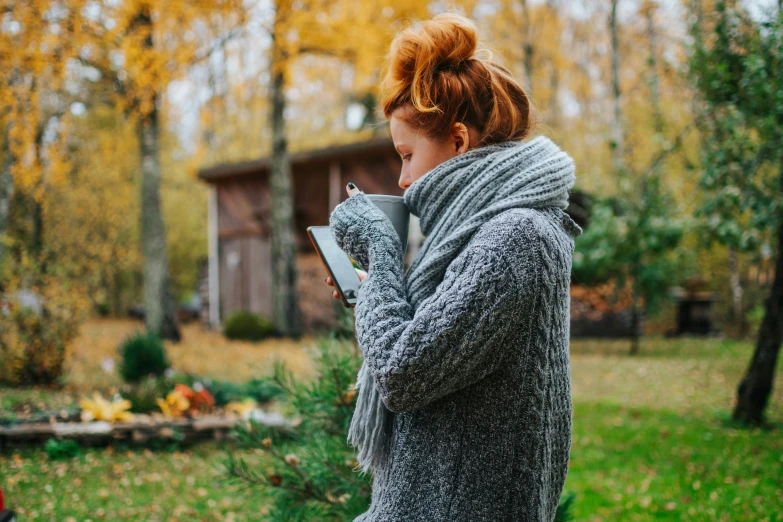 woman holding an ipad looking at autumn flowers