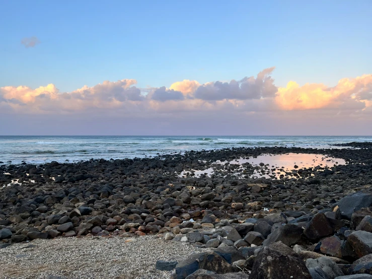 a white and black rock beach and water