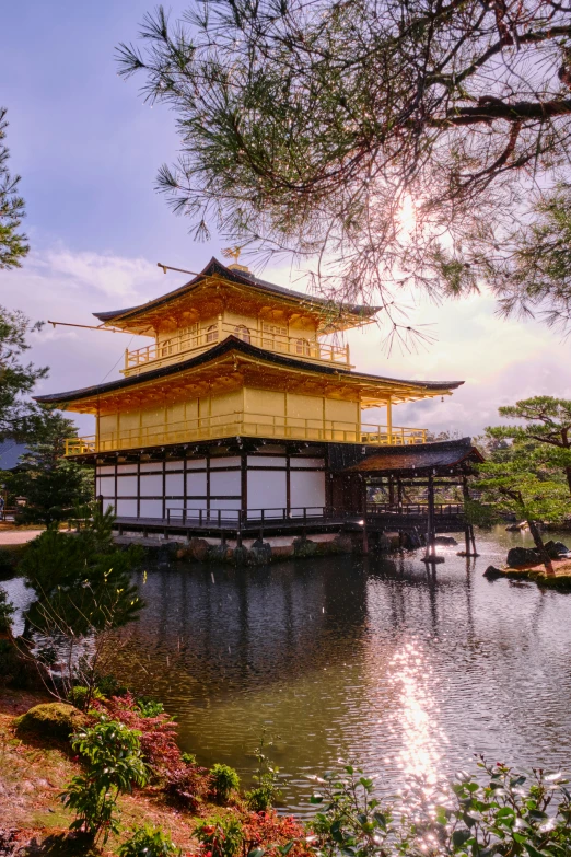 a yellow structure surrounded by greenery and water