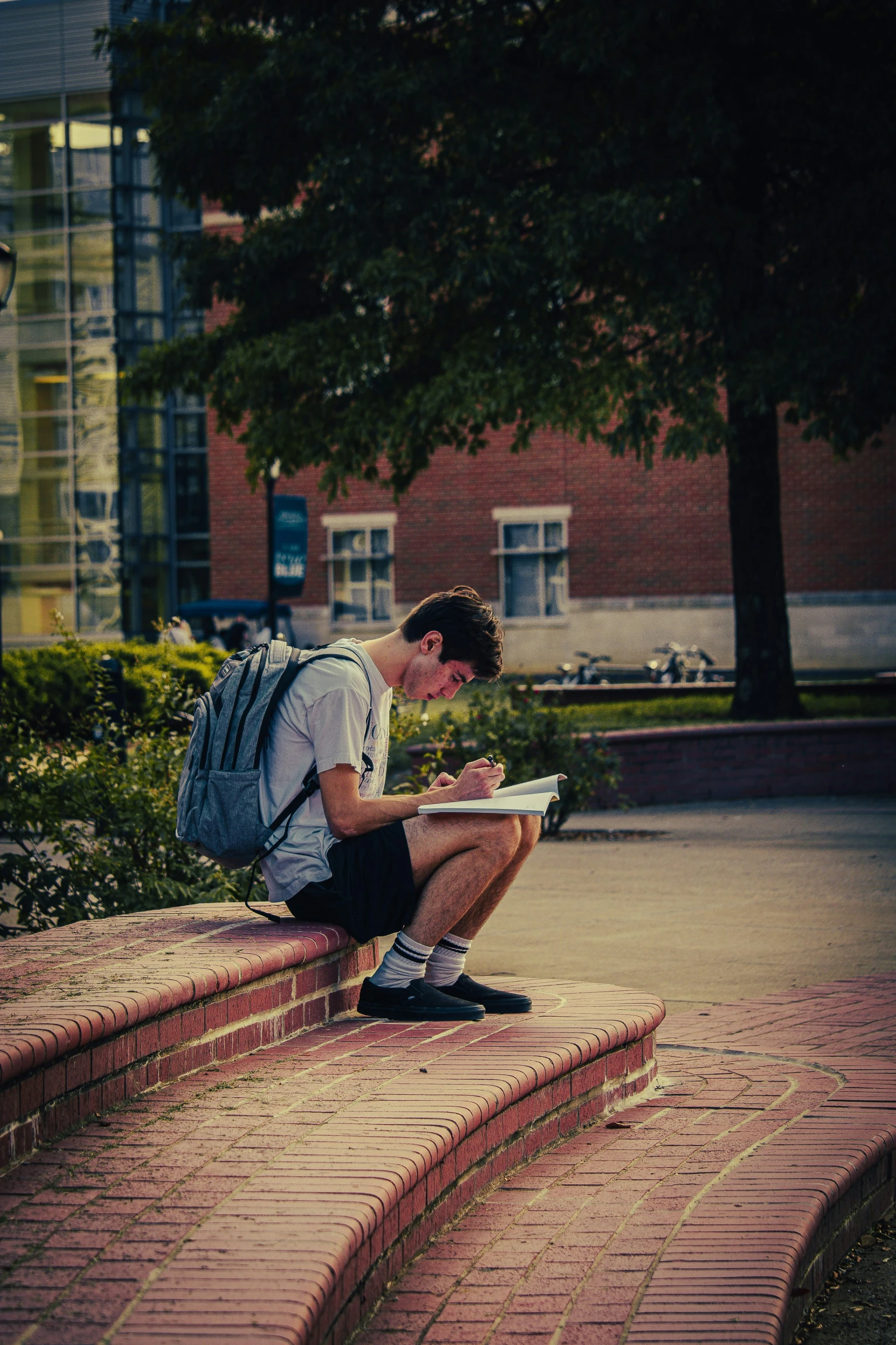 a young man is sitting down with a backpack and some books