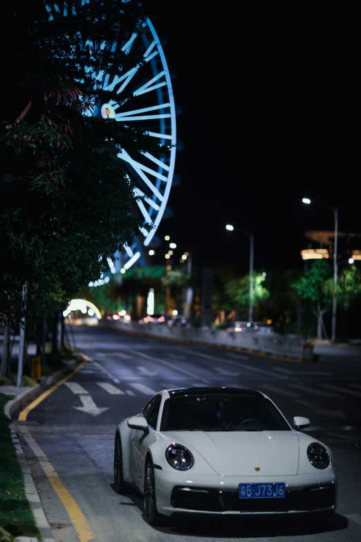 a white porsche in the dark with an elaborate wheel