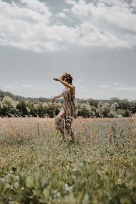 woman in a field of grass holding a frisbee