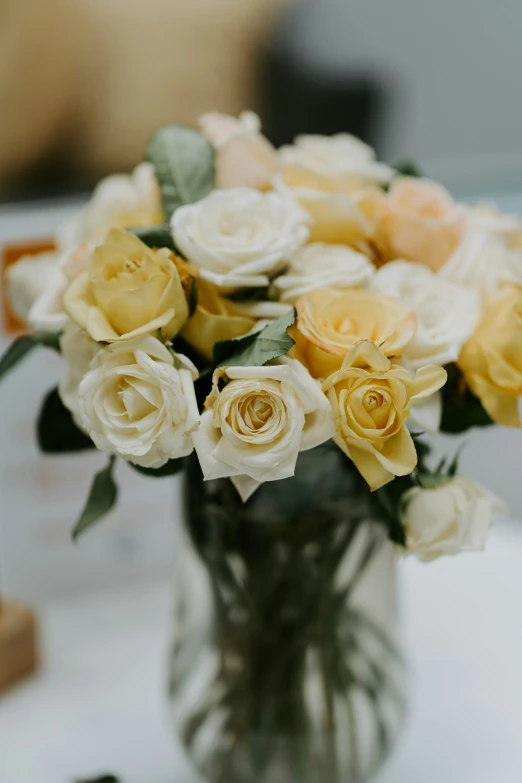 a vase filled with yellow and white flowers on a table