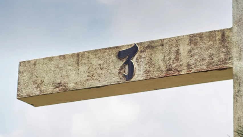 a weathered street sign shows a left handed curve