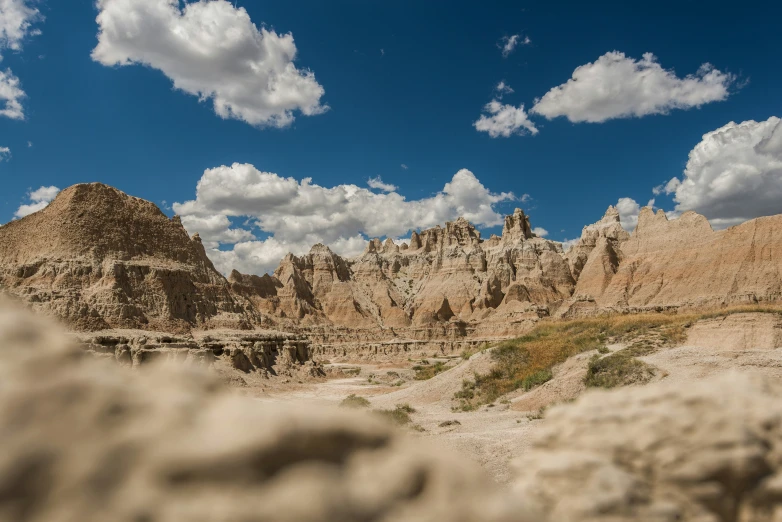 a mountain landscape under some blue sky and white clouds