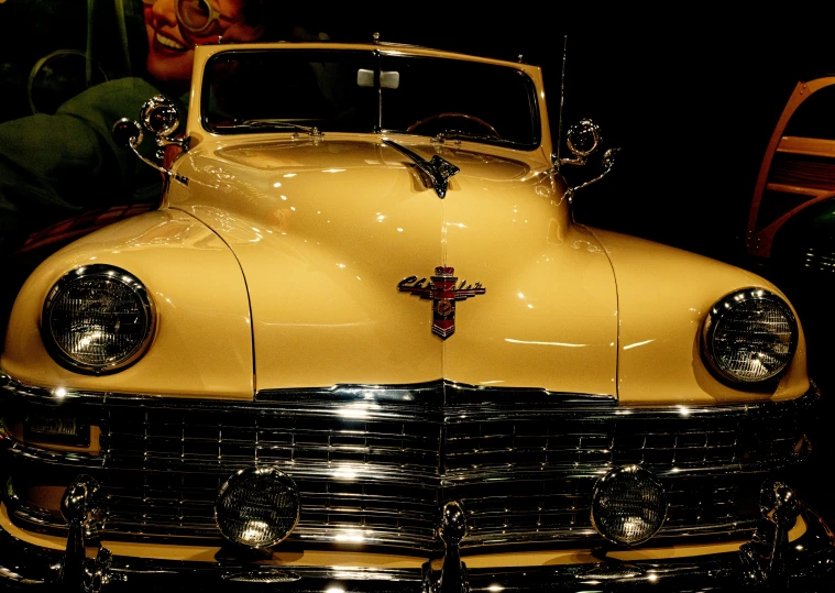 an old yellow car parked inside of a garage