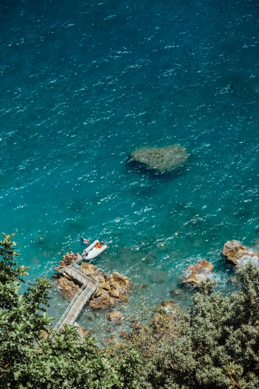 a dock and boat at the edge of a lake with trees