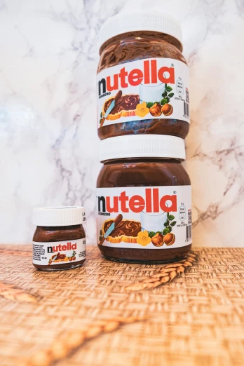 a wooden table topped with jars of nutella