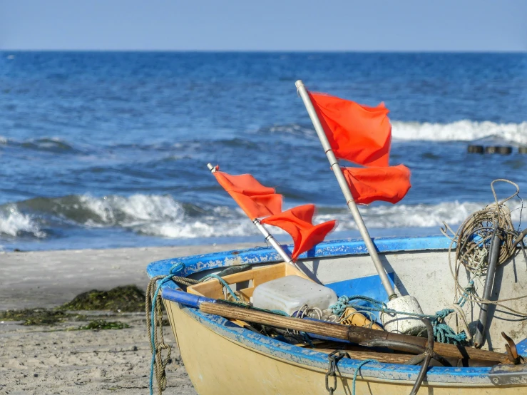 an old boat on the beach with flags