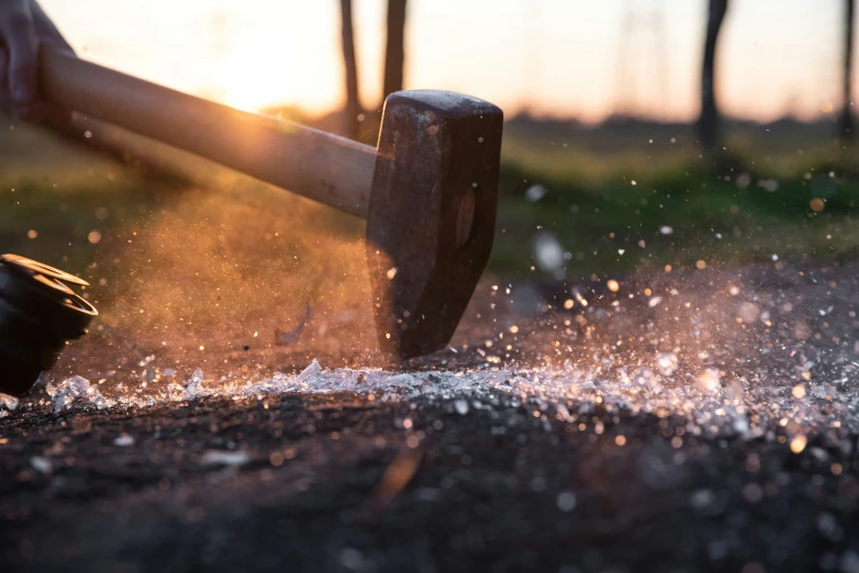 a hammer hitting a metal piece on top of a street