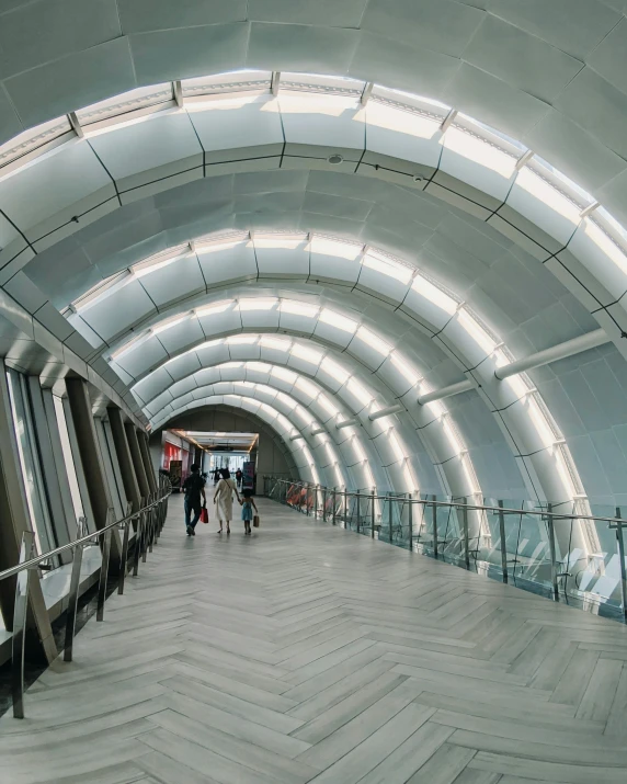 some people are walking down the escalator towards the camera