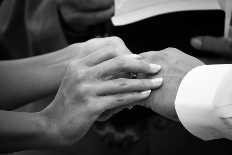 a bride and groom hold hands close to one another
