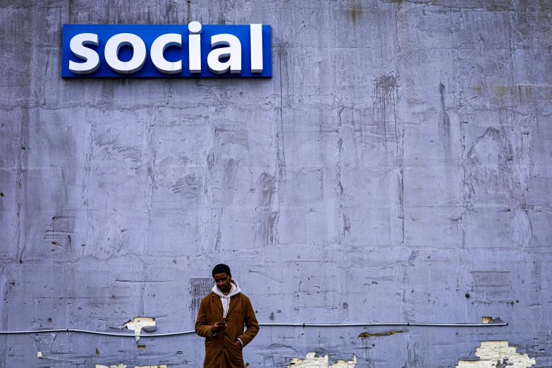 a man standing in front of a wall with the word social painted on it